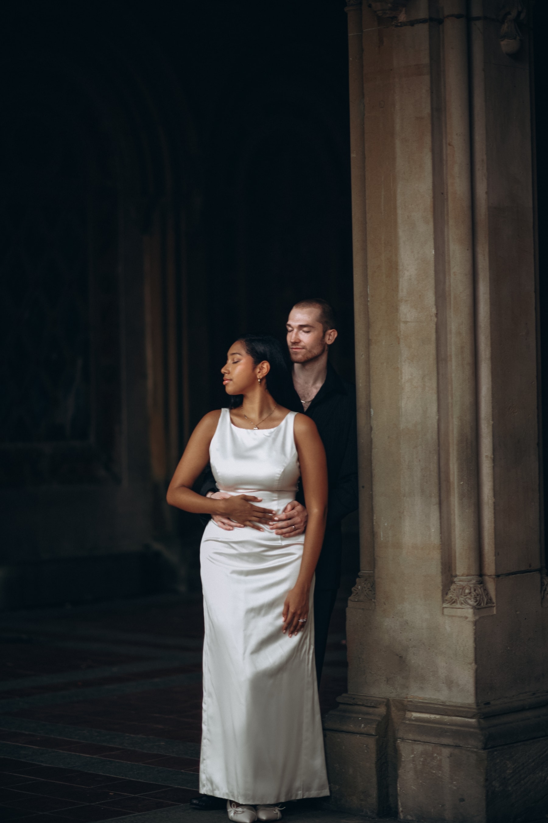 June and Elias beneath the painted arcade of Bethesda Terrace, standing in a column of light