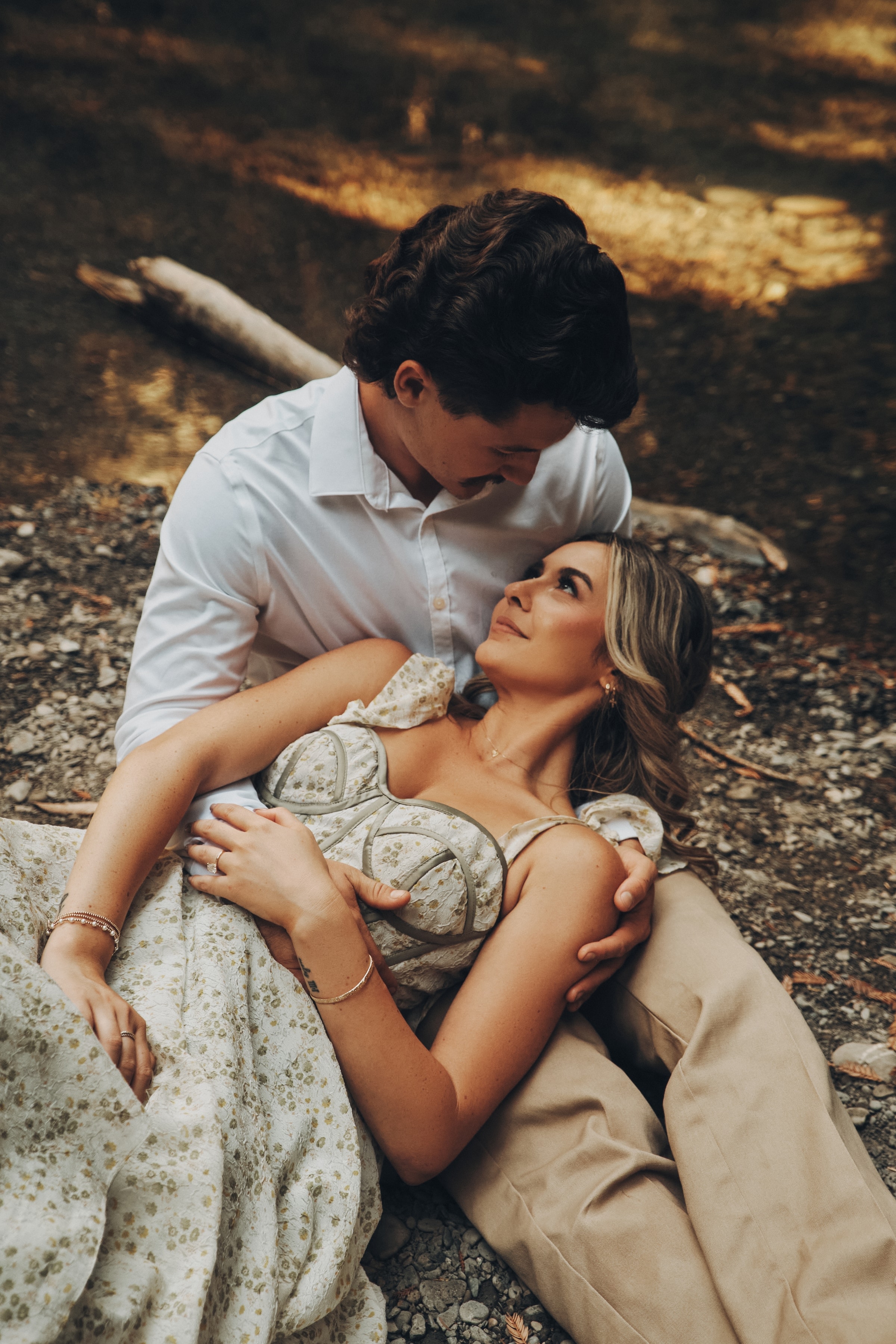 Bride and groom reclining together in warm redwood light