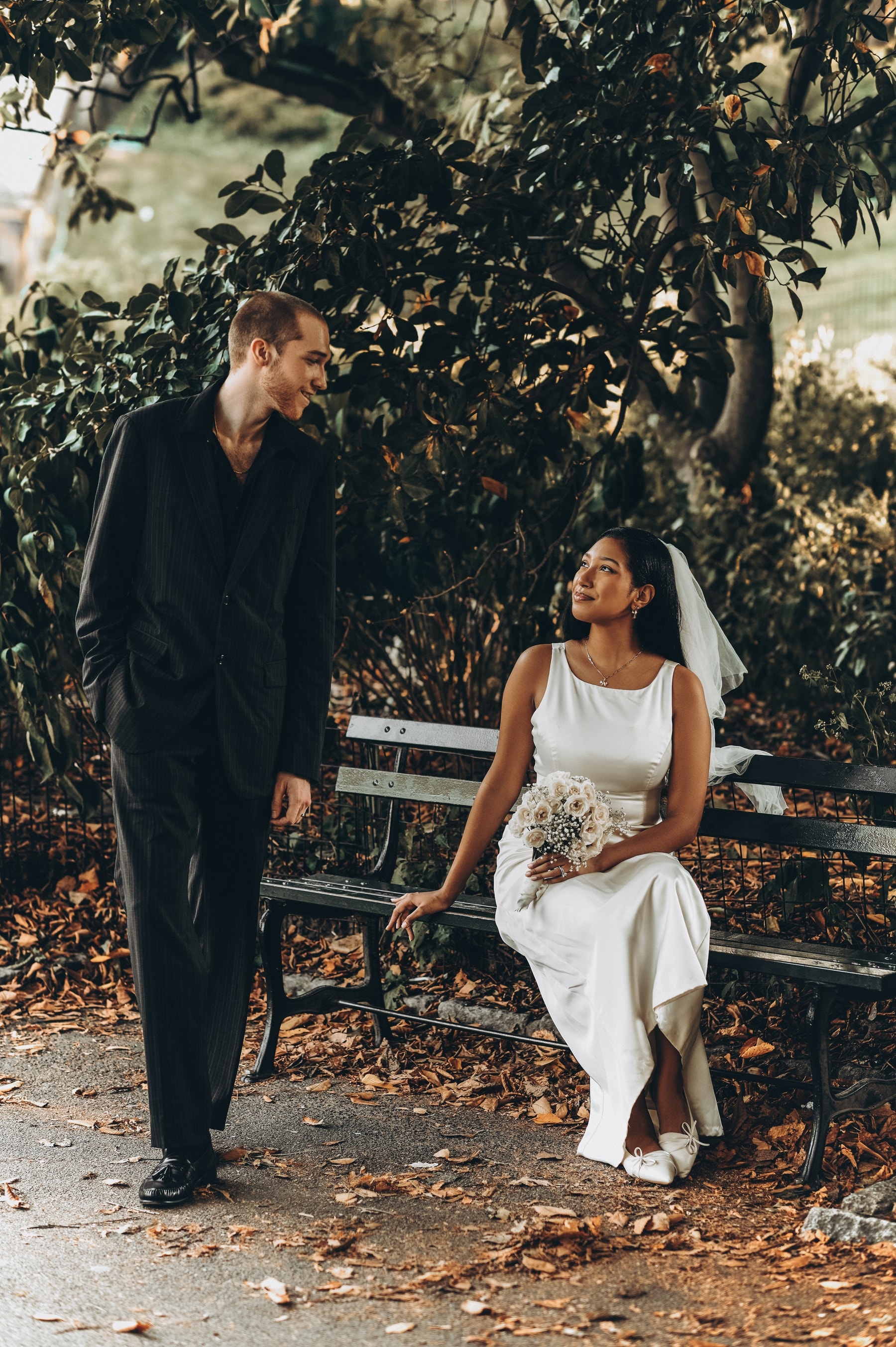 Groom kissing the bride's hand beneath her veil, Central Park, New York